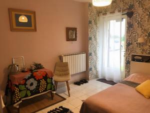 una camera da letto con un letto, una sedia e una finestra di Chambres Au Calme, À La Campagne a Durtal