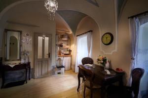 a living room with a table and a clock on the wall at Apartman Charlotte v Dome so studňou na streche in Banská Štiavnica
