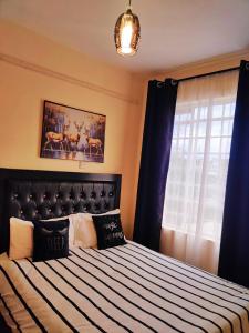 a bedroom with a large bed with blue curtains at Reigns home in Eldoret