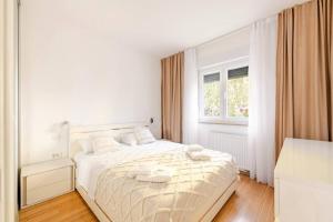 una camera da letto bianca con un letto e asciugamani di Apartment with private Swimming pool a Trogir