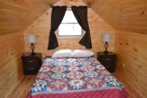 una camera da letto con un letto con due comodini e una finestra di Blue Rose Cabins - Naughty Pine Cabin a Logan