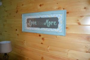 un cartello su un muro di legno con un cartello che dice "sei per sempre" di Blue Rose Cabins - Naughty Pine Cabin a Logan