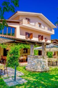 a large house with tables and chairs in front of it at Country House Il Piacere in Civitella del Tronto