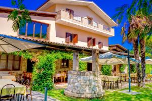 a house with tables and chairs in front of it at Country House Il Piacere in Civitella del Tronto