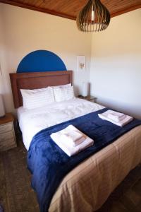 a bedroom with a large bed with towels on it at Lovely 3 bed house in Juliasdale - 2273 in Nyanga
