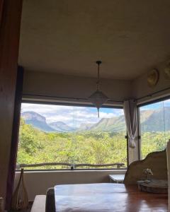 パウメイラスにあるLoft Urucumのベッドルーム1室(山の景色を望む大きな窓付)