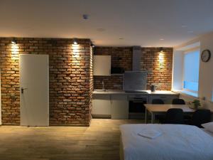 a kitchen and dining room with a brick wall at Studio3 in Utena
