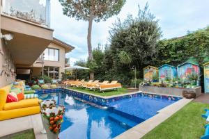 a backyard with a pool with chairs and a house at Magic Forte in Forte dei Marmi