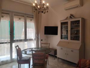 a dining room with a table and a chandelier at Appartamento silenzioso comodo alle spiagge e stazione ferroviaria in Lavagna