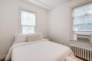 una camera da letto bianca con un letto e due finestre di 1 Mi to Arts District Modern Hyattsville Hideaway a Hyattsville