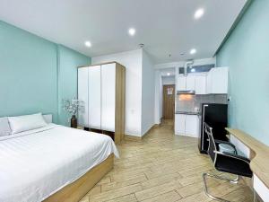 a bedroom with a large bed and a kitchen at MIDMOST C22 Apartment in Can Tho