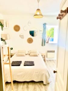Una habitación blanca con una cama y una ventana en Chez gaillard petit studio sans cuisine entièrement rénové au calme, en Ussel