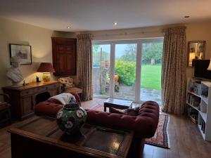 a living room with a couch and a large window at Writer's Retreat in Swanmore
