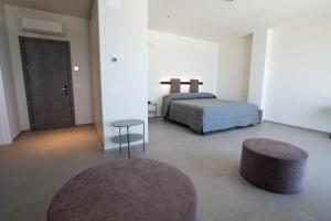 a bedroom with a bed and a table and a stool at Hotel Il Caminetto in Porto San Giorgio