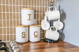 a group of coffee cups on a counter in a kitchen at Charming Apartment - City Centre - Free Parking, Self-Check-In, Balcony and Smart TV with Sky TV and Netflix by Yoko Property in Milton Keynes