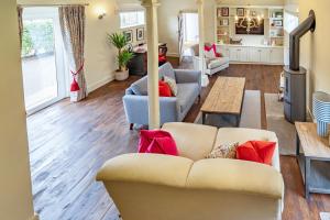 a living room with a couch and a table at Coach House with Hot Tub in Idyllic Bury St Edmunds 