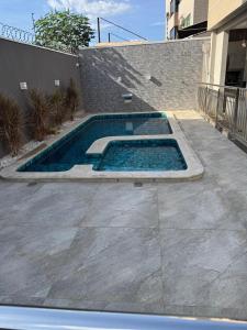 a swimming pool in a yard next to a building at Apartamento Prime 02 in Palmas