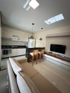 a living room with a couch and a kitchen at Apartamento Prime 02 in Palmas +5 photos