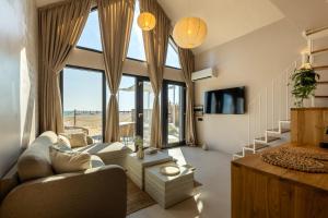 a living room with a couch and a large window at Oasis Village Eforie Nord in Eforie Sud