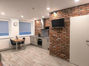 a kitchen with a brick wall and a table at Studio 2 in Utena