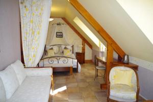 a attic room with a bed and a couch at Gite de La Lauzeraie in La Bourboule
