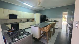 Una cocina con gabinetes blancos y un horno de estufa. en Charming 3 bedroom guesthouse - 2300, en Kariba