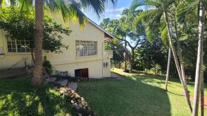 una casa con palmeras frente a un patio en Charming 3 bedroom guesthouse - 2300, en Kariba