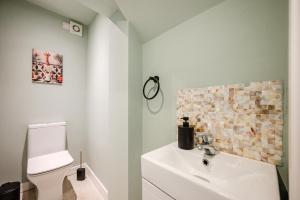 a bathroom with a white sink and a toilet at Hilton House - stylish 4-bed with parking in Manchester +24 photos