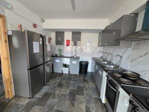 a large kitchen with stainless steel appliances and tile floors at Rooms by Southgate Station Budget Mid to Long Term Stay in East Barnet
