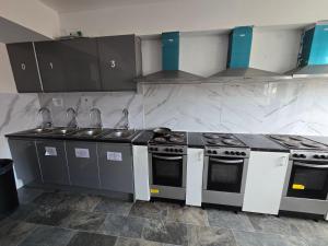 a kitchen with stove and sink in a room at Rooms by Southgate Station Budget Mid to Long Term Stay in East Barnet