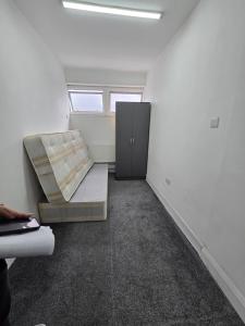 a room with a bed and a cabinet in it at Rooms by Southgate Station Budget Mid to Long Term Stay in East Barnet