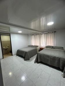 a bedroom with two beds and a window with curtains at Apartamento Céntrico y cómodo en Cali in Cali