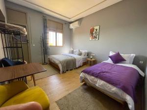 a bedroom with two beds and a table at Palm Garden in Erfoud