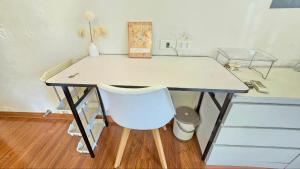 a desk with a chair and a table with a drawer at HnHome54AC in Hanoi