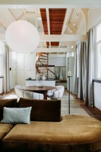 a living room with a couch and a table at MUS - Design accommodation with hot tub in Horssen