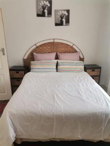 a bedroom with a white bed with two pillows at NEMARA Self Catering Lodge in Polokwane