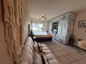 una sala de estar con un sofá y una cama en Departamento en la Playa, en Cancún