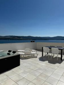 a patio with a table and chairs and a hot tub at Holiday Home Premium in Komarna