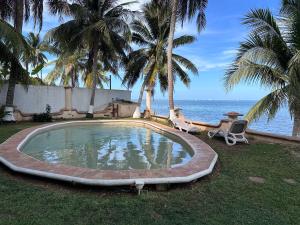 una piscina con palmeras y el océano en Departamento en la Playa, en Cancún