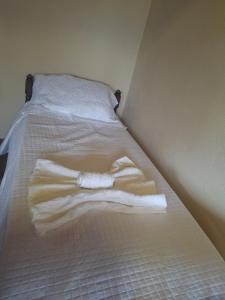 a white towel laying on a bed in a room at Casa de Luz - Lar na Serra - Suite - Duplo ou Triplo - N4 in Miguel Pereira +2 photos