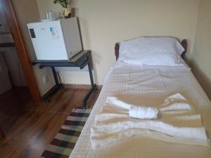 a bed with a white blanket and a table at Casa de Luz - Lar na Serra - Suite - Duplo ou Triplo - N4 in Miguel Pereira