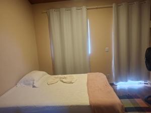 a bedroom with a bed with white sheets and a window at Casa de Luz - Lar na Serra - Suite - Duplo ou Triplo - N4 in Miguel Pereira