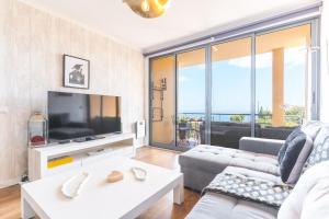 een woonkamer met een bank en een tv bij Vista Mar by Atlantic Holiday in Caniço