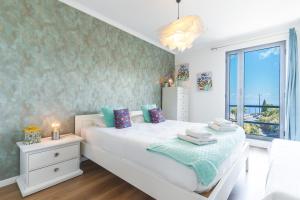 een slaapkamer met een wit bed en een raam bij Vista Mar by Atlantic Holiday in Caniço