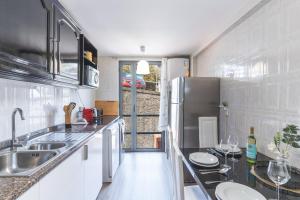 een keuken met een spoelbak en een koelkast bij Vista Mar by Atlantic Holiday in Caniço +18 foto's