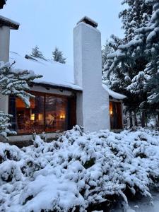 a house with a pile of snow in front of it at Nevada Hostel in San Carlos de Bariloche