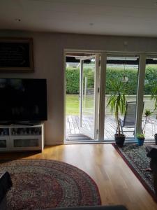 a living room with a television and a sliding glass door at ossama in Åstorp