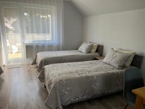 a bedroom with two beds and a window at Rene-Stay-Naisiai in Naisiai