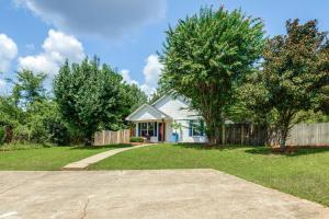 a house with a fence and a grass yard at 1 Mi to Ole Miss Pet-Friendly Retreat with Yard in Oxford