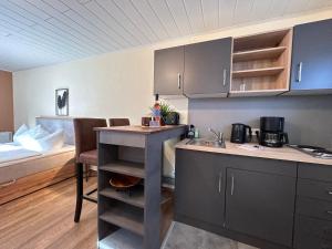 eine Küche mit einem Tisch und einem Bett in einem Zimmer in der Unterkunft Bungalow Strandlicht im Seebad Bansin in Heringsdorf